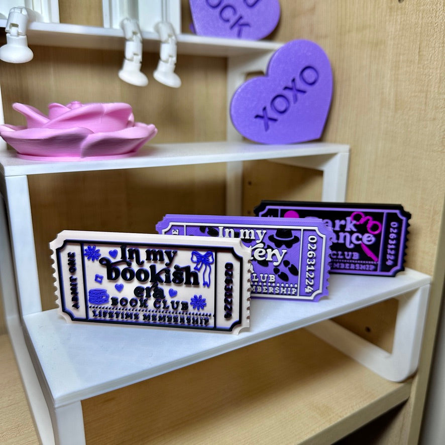Book club ticket decorations displayed on a shelf